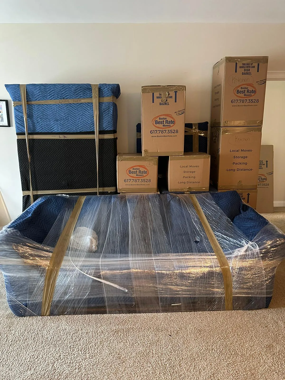 Furniture protected with moving blankets and Boston Best Rate Movers branded boxes