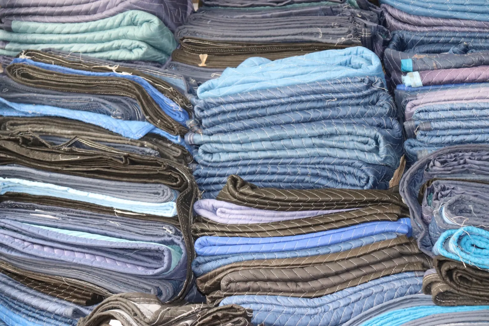 Professional moving blankets stacked and ready for furniture protection