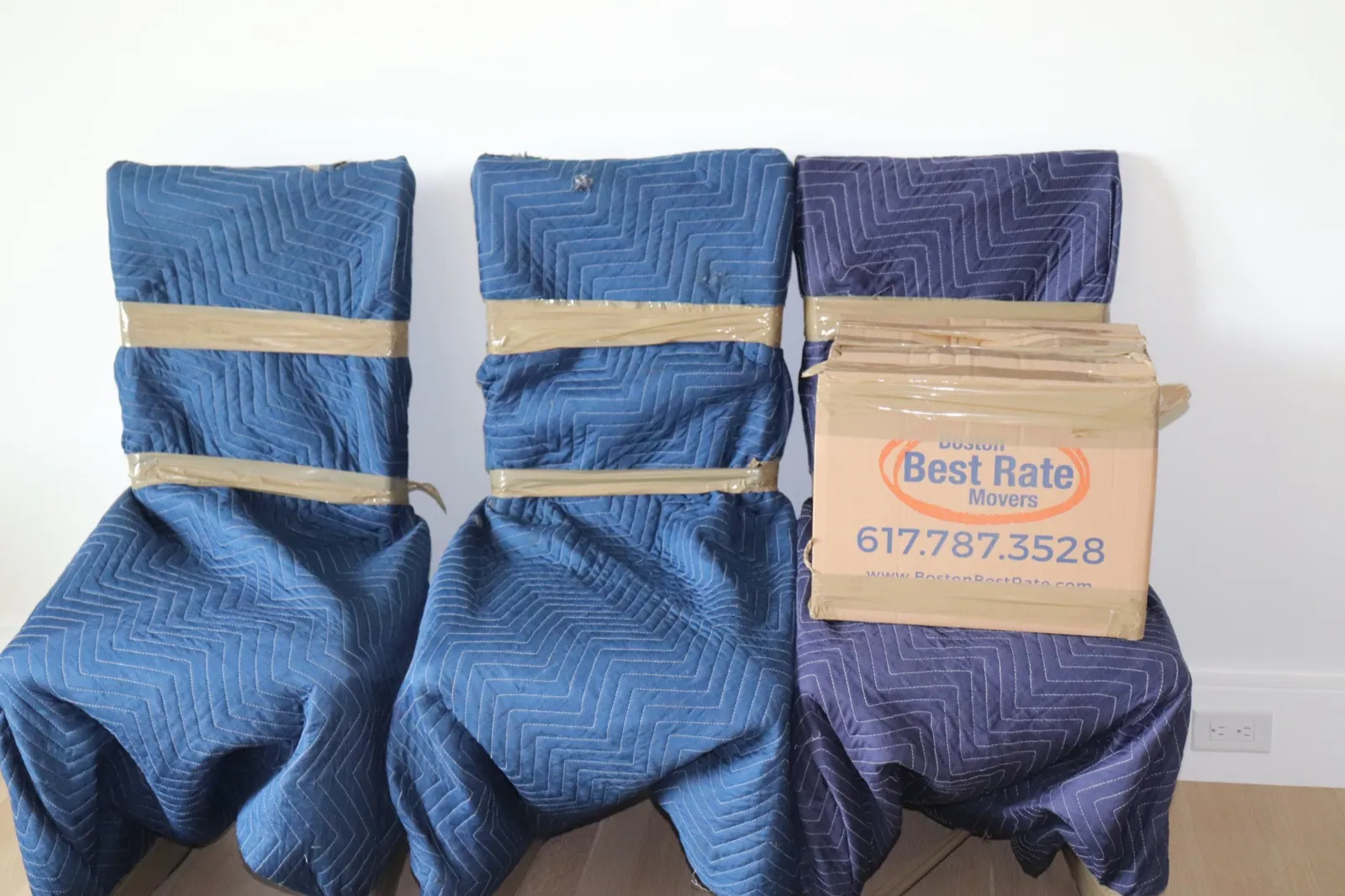 Dining chairs carefully wrapped in protective blankets for moving