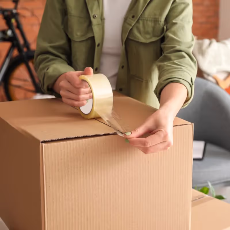 Packing tape being applied to moving box for secure sealing