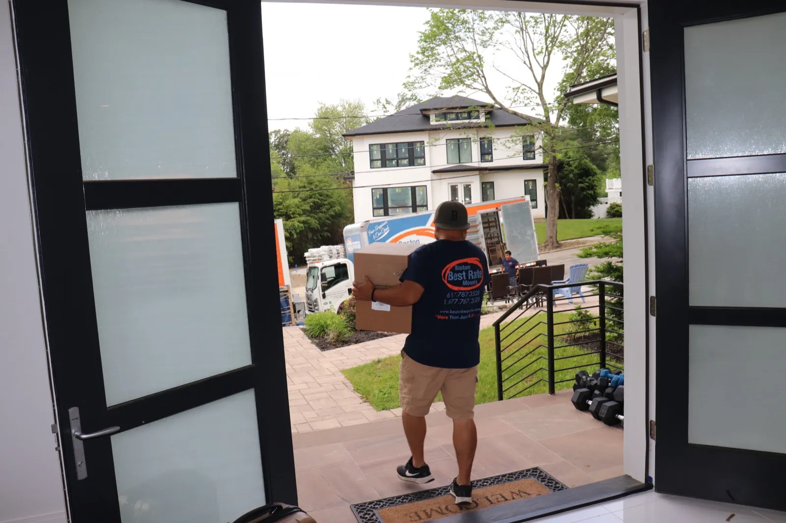 Boston Best Rate Movers crew member delivering boxes to a home