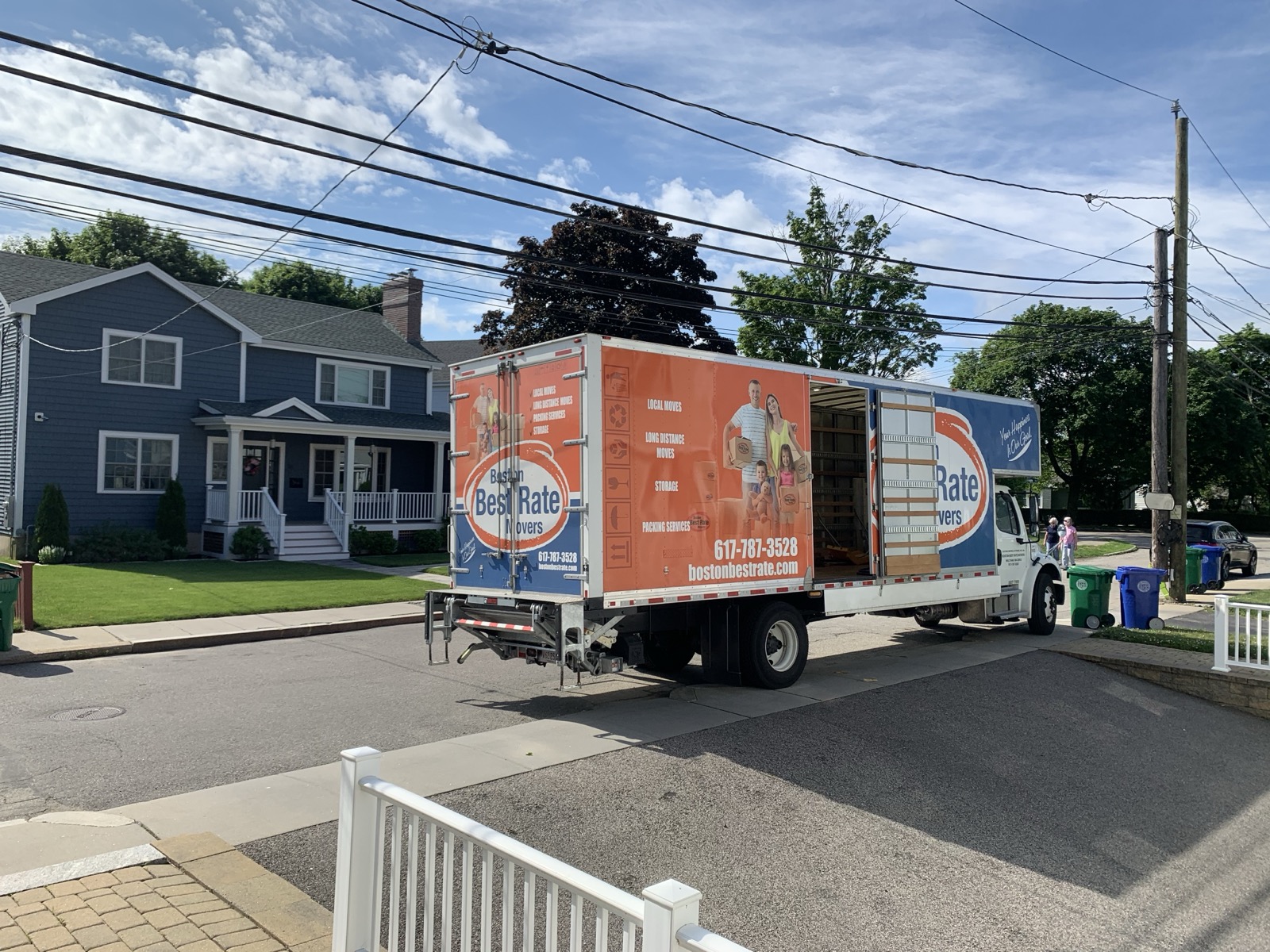 Boston Best Rate Movers truck with ramp deployed in suburban neighborhood